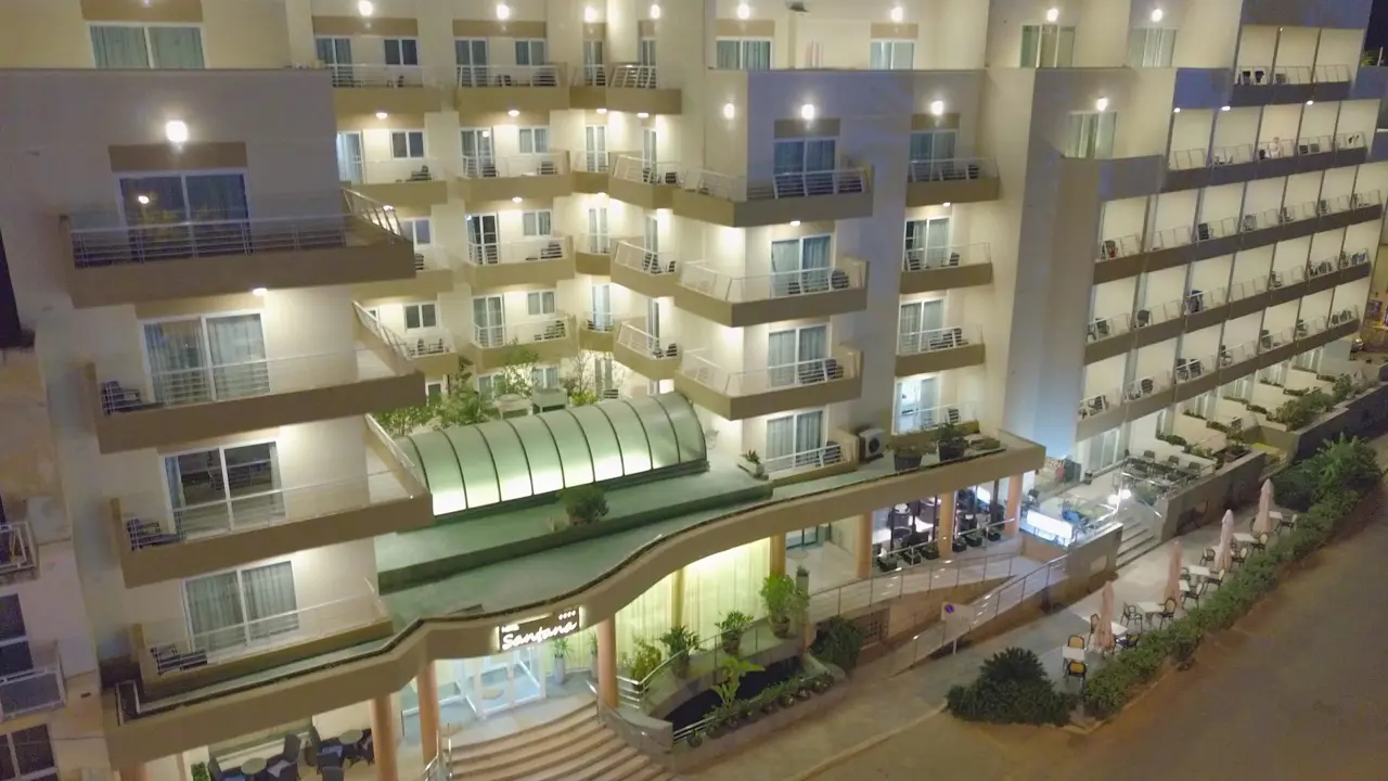 Exterior of Hotel Santana in St Paul’s Bay, Malta at night, with the building brightly lit and balconies visible
